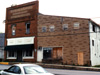 Another photograph of a classic small-town storefront that no longer exists. Together with the tacky fake-stone-facade expansion at right, the building at left had managed to hang on to life and house a number of businesses. Some of the upper-story space had been used as apartments as recently as the 2000s. Unfortunately, shortly after being vacated, both buildings fell into disrepair and were demolished in 2006.